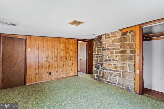 empty room with carpet flooring and wood walls