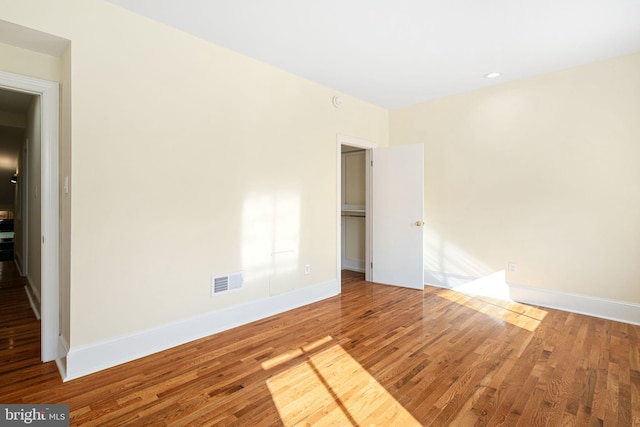 unfurnished bedroom featuring wood finished floors, visible vents, and baseboards