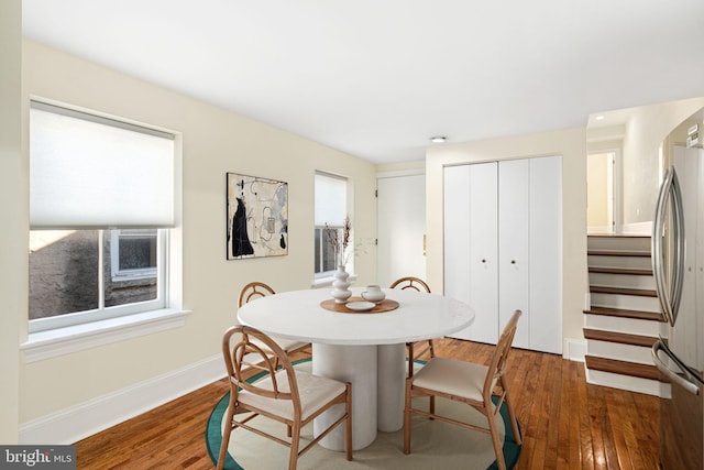 dining space featuring a wealth of natural light, stairway, baseboards, and wood-type flooring