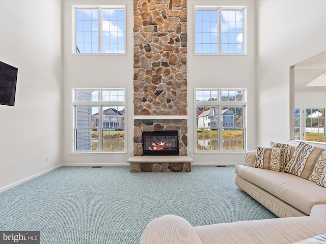 living area featuring plenty of natural light, a towering ceiling, and carpet floors