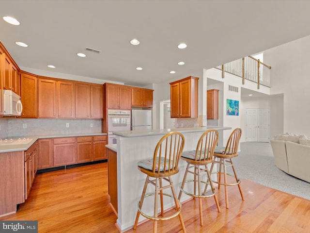 kitchen featuring visible vents, white appliances, and light countertops