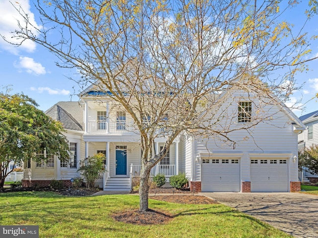 view of front facade with driveway, a porch, a front yard, a garage, and a balcony