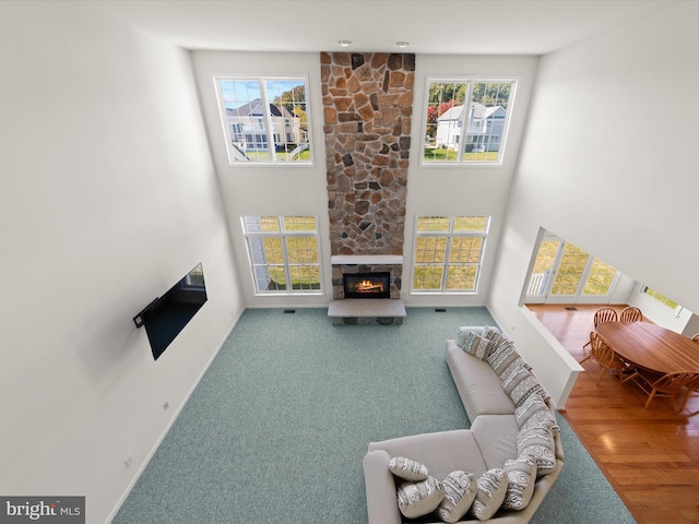 living room featuring carpet flooring, plenty of natural light, baseboards, and a fireplace