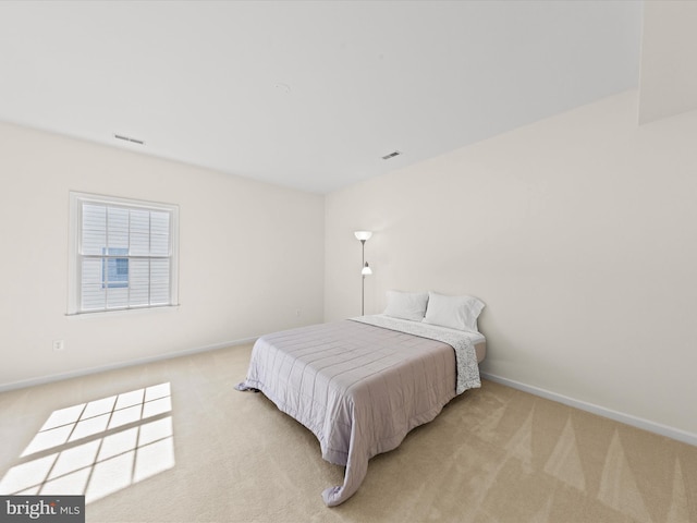 bedroom with light colored carpet, visible vents, and baseboards