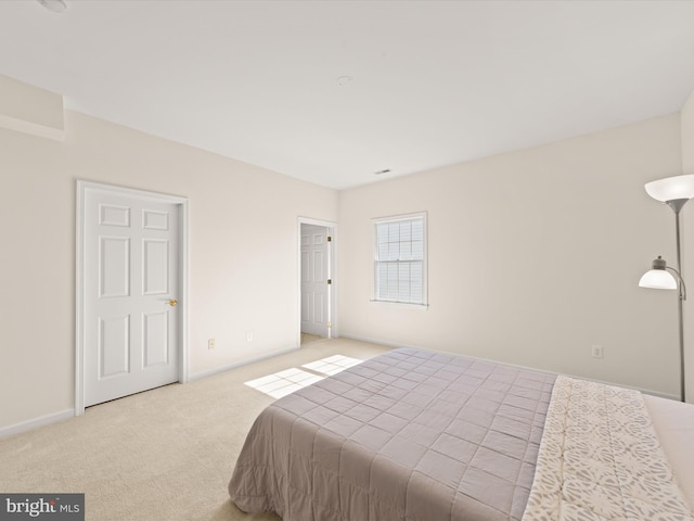 bedroom with baseboards and light carpet