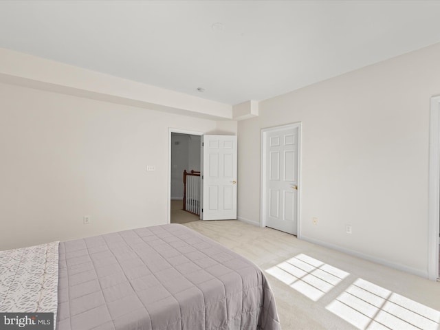 bedroom featuring baseboards and light carpet