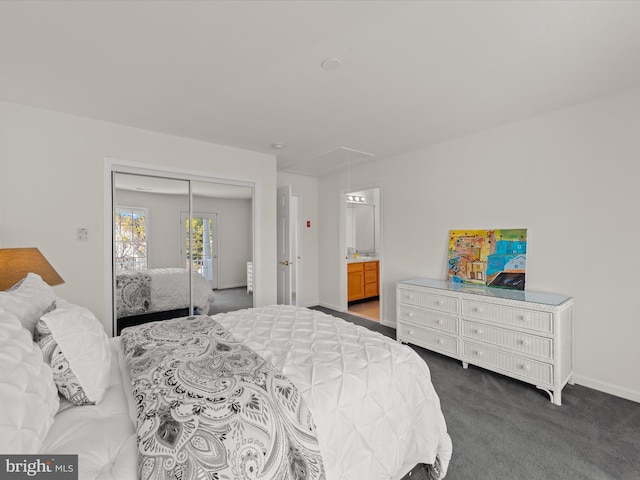 bedroom with baseboards, ensuite bath, attic access, a closet, and carpet flooring