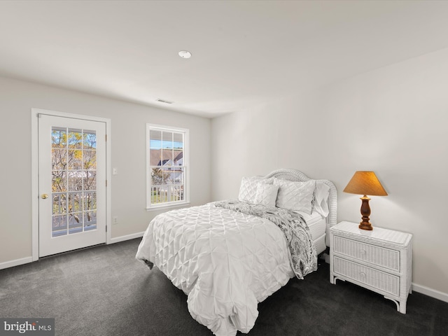 carpeted bedroom with visible vents, baseboards, and access to exterior