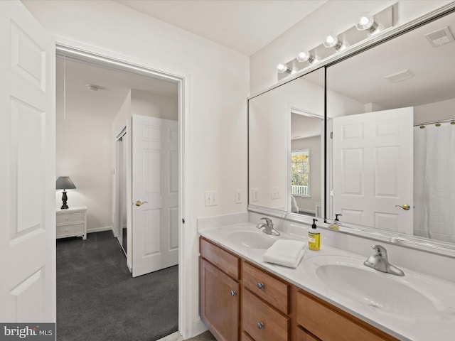 bathroom with double vanity, visible vents, and a sink