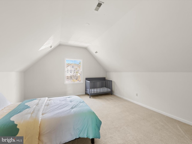 carpeted bedroom featuring visible vents, baseboards, and lofted ceiling with skylight