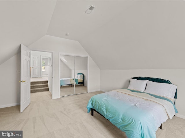 carpeted bedroom featuring baseboards, visible vents, lofted ceiling, and a closet