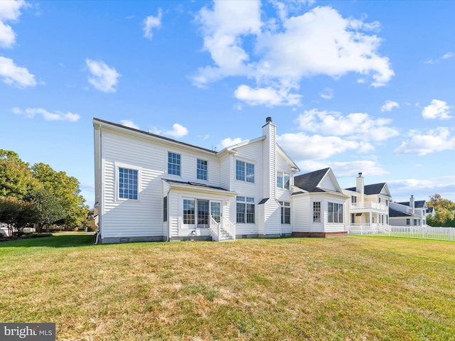 back of property featuring a chimney, a lawn, fence, and crawl space