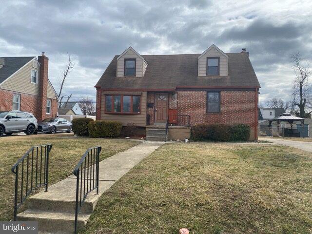 view of front facade featuring brick siding and a front lawn