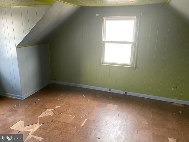 bonus room with baseboards and lofted ceiling