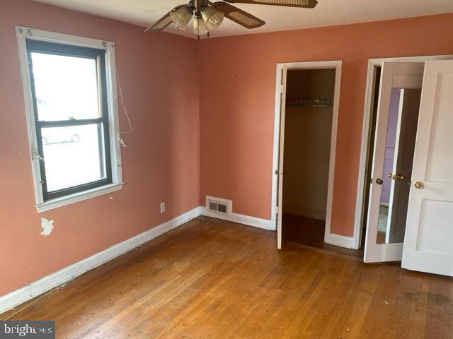 unfurnished bedroom featuring visible vents, light wood-type flooring, a closet, and baseboards