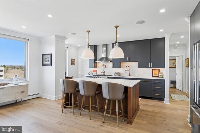 191 Presidential Blvd Unit R1018-1019, Bala Cynwyd, PA 19004 - kitchen with wall chimney exhaust hood, light countertops, decorative backsplash, a center island, and light wood-style floors