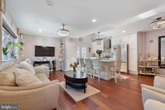 living room featuring recessed lighting, dark wood-type flooring, and an inviting chandelier