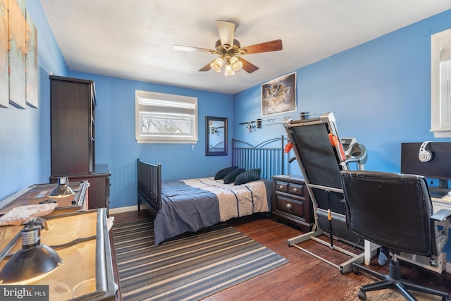 bedroom with ceiling fan, baseboards, and wood finished floors