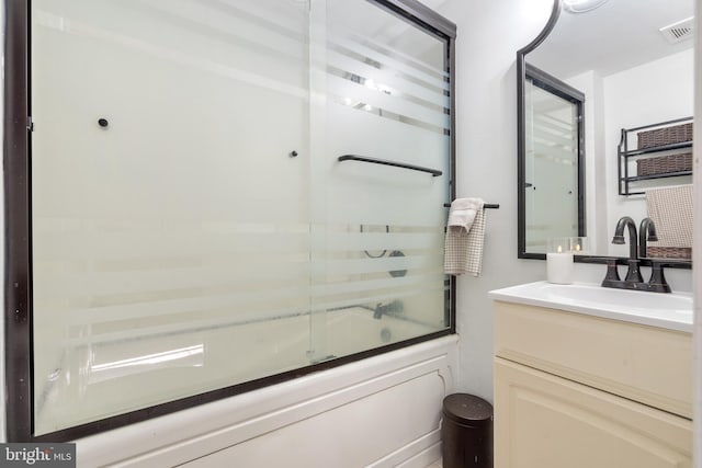 full bath featuring visible vents, vanity, and bath / shower combo with glass door