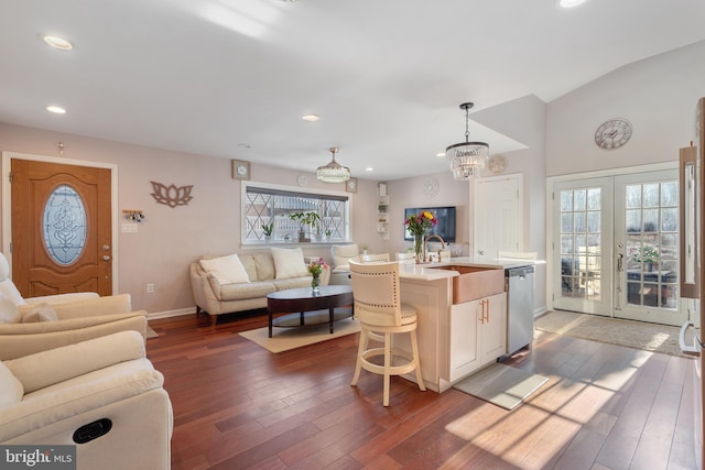 kitchen with open floor plan, a sink, light countertops, and stainless steel dishwasher