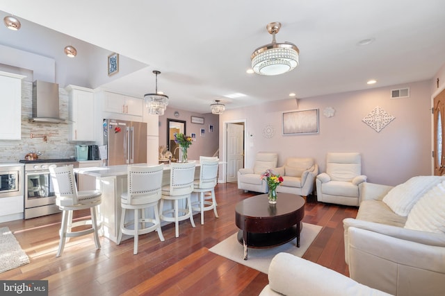 living room with visible vents, recessed lighting, and hardwood / wood-style floors