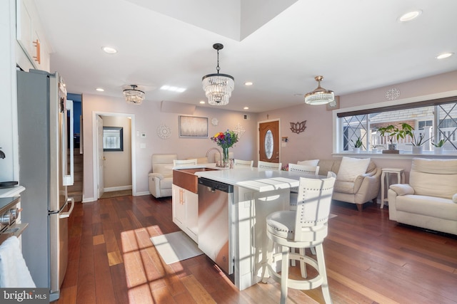 kitchen with dark wood finished floors, open floor plan, light countertops, appliances with stainless steel finishes, and white cabinets