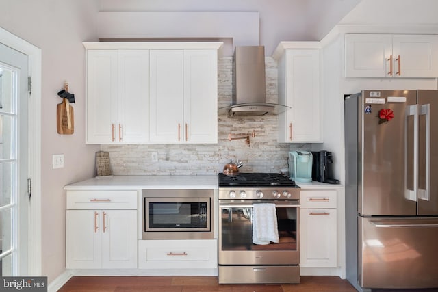 kitchen featuring white cabinets, wall chimney exhaust hood, backsplash, and stainless steel appliances