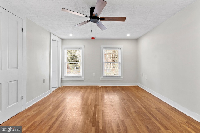 unfurnished room with baseboards, ceiling fan, recessed lighting, light wood-style flooring, and a textured ceiling