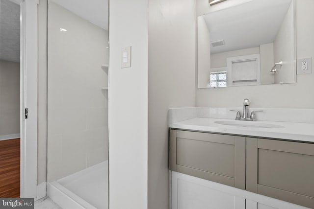 full bathroom featuring visible vents, a shower stall, vanity, and baseboards