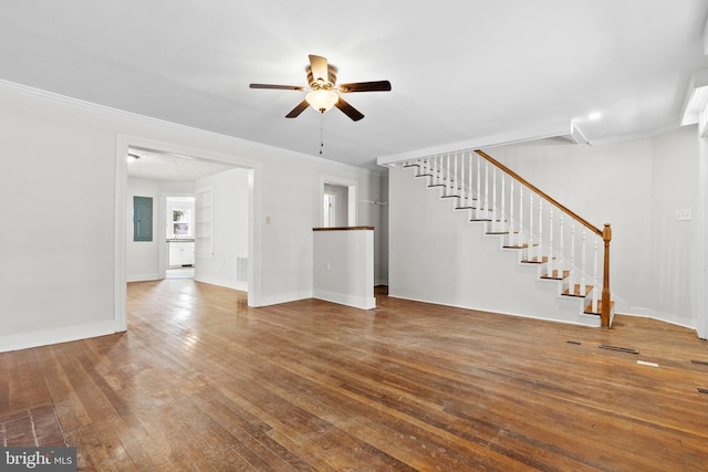 unfurnished living room featuring crown molding, baseboards, stairs, a ceiling fan, and wood-type flooring