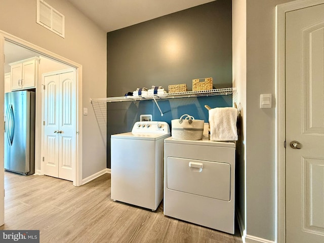 laundry room with light wood finished floors, laundry area, washing machine and dryer, and visible vents