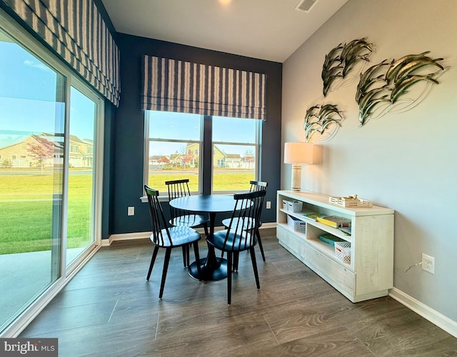 dining room with dark wood-type flooring, visible vents, and baseboards