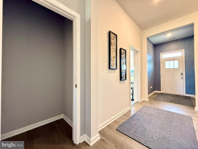 foyer entrance featuring baseboards and wood finished floors