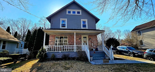 view of front of house featuring brick siding and covered porch