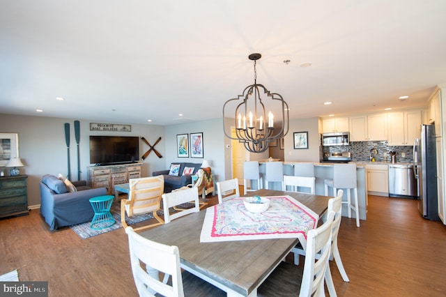 dining space with recessed lighting, an inviting chandelier, and wood finished floors