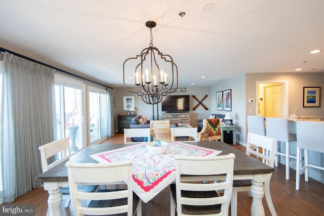 dining space with recessed lighting, baseboards, an inviting chandelier, and wood finished floors