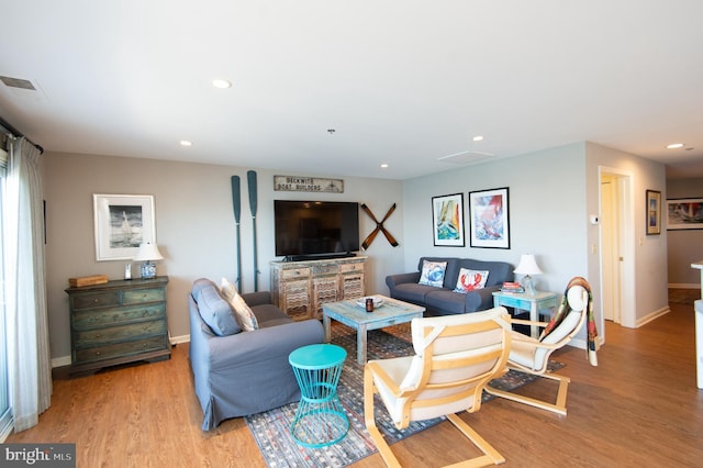 living room featuring visible vents, recessed lighting, baseboards, and light wood finished floors