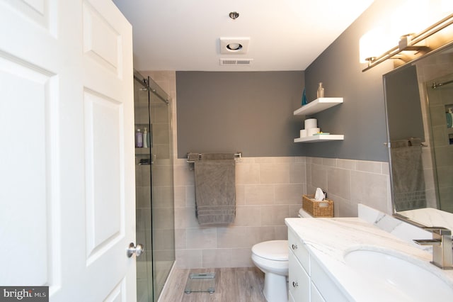 full bath featuring visible vents, toilet, a stall shower, and tile walls