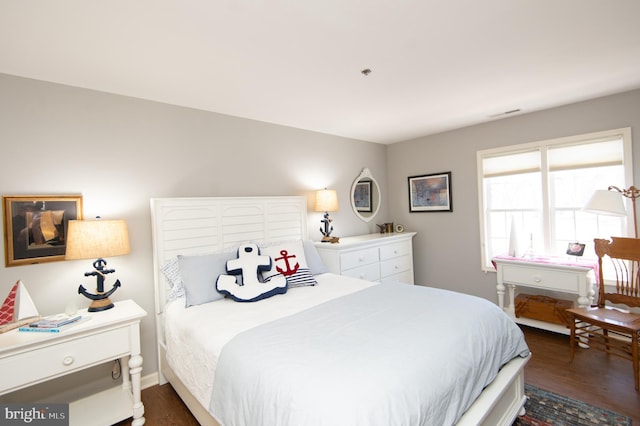 bedroom featuring dark wood finished floors and baseboards