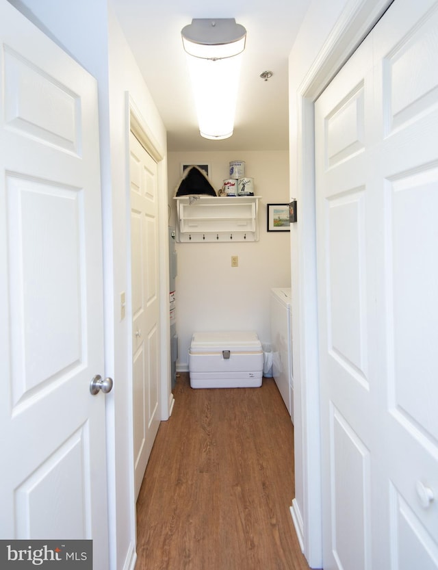 hallway with separate washer and dryer and wood finished floors