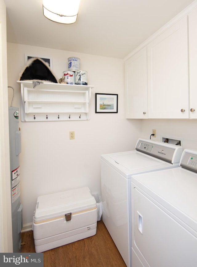 washroom featuring wood finished floors, cabinet space, electric water heater, and washer and clothes dryer