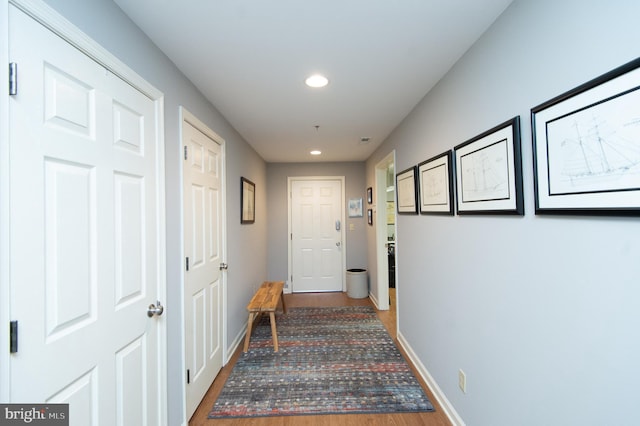 hall with recessed lighting, wood finished floors, and baseboards