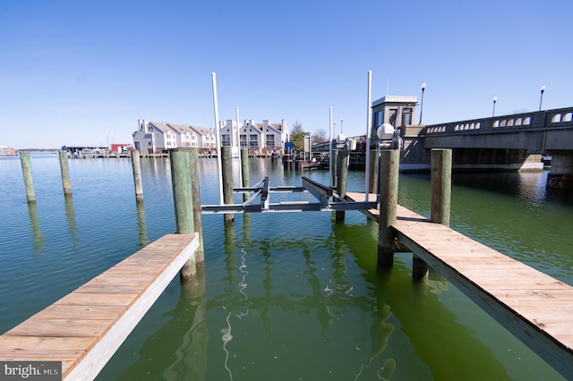 view of dock featuring a water view, a residential view, and boat lift