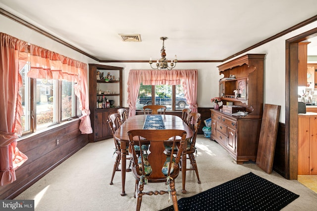 dining area featuring visible vents, light colored carpet, a chandelier, and wood walls