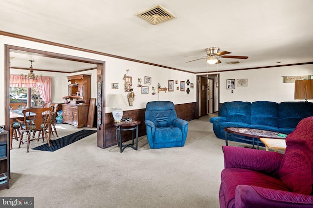 living room with a wainscoted wall, crown molding, visible vents, and carpet floors