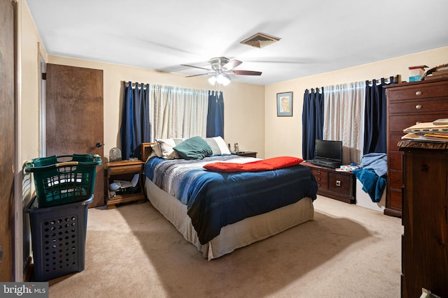 bedroom featuring visible vents, light colored carpet, and ceiling fan