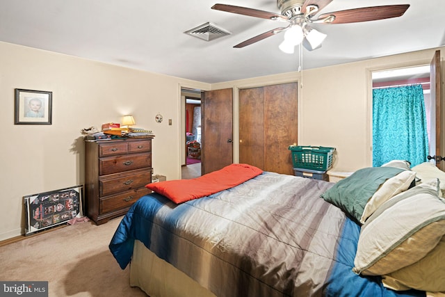 bedroom with a closet, visible vents, ceiling fan, and carpet