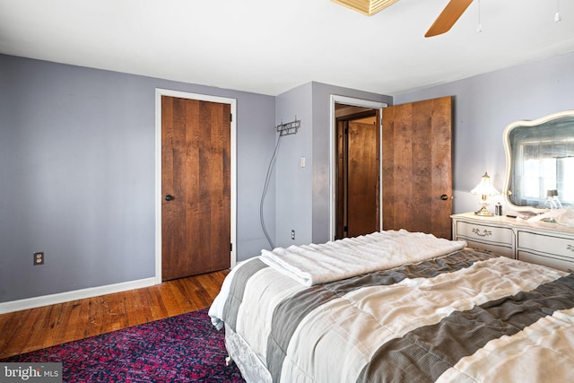 bedroom with a ceiling fan, wood finished floors, and baseboards