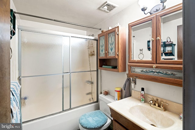 full bathroom with vanity, toilet, visible vents, and bath / shower combo with glass door