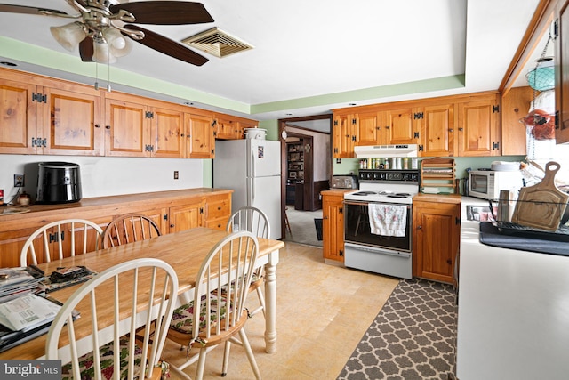 kitchen with under cabinet range hood, visible vents, white appliances, and light countertops